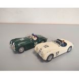 Two Jaguar XK 120 model cars by Ninco in clear perspex cases. (2)