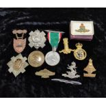 Collection of military cap badges including Tarnaki Rifles X1 Regiment, Royal Defence Corps and