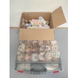 Two boxes containing a large quantity of mixed world postage stamps.