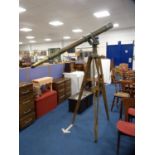 Large brass military-style telescope on gimble mount and wooden tripod stand.