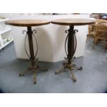 Pair of tall pub tables on metal bases.