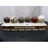 'The Development of the Golf Ball' reproduction set of six antique-style faux golf balls on stand.