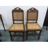 Pair of carved oak hall chairs with bergere backs and seats.