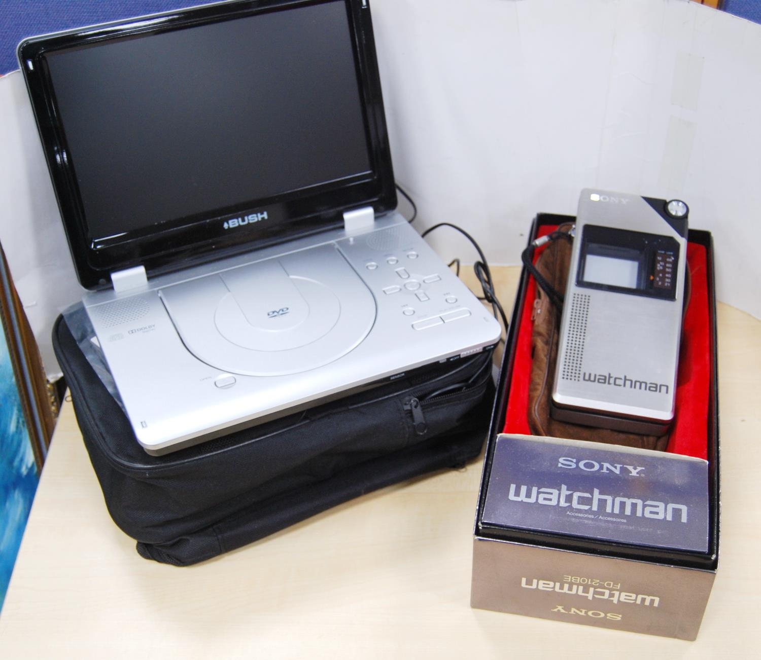 Bush portable DVD player with carry bag and accessories, and a boxed Sony Watchman with pouch.