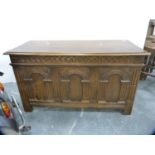 Carved oak blanket box with arcaded panel.