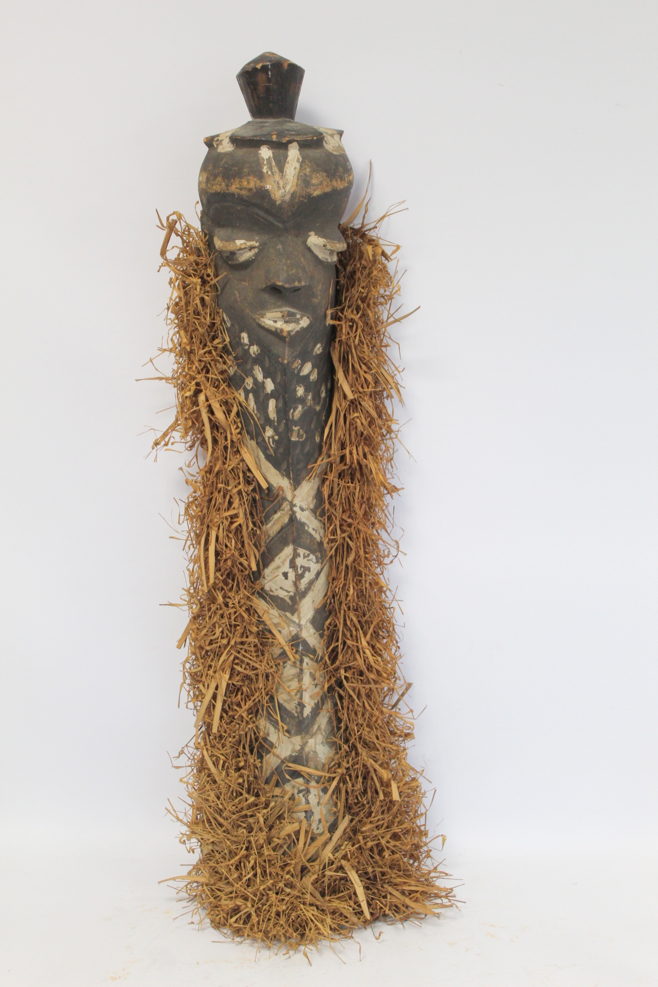 African tribal carved wooden mask of elongated form, with carved and painted facial features, border