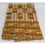African Asanti Kente cloth in woven silk and cotton striped fabrics in predominantly yellow,