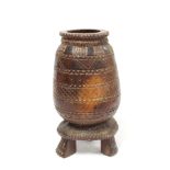 Carved African hardwood grinding pot or mortar of ovoid form on triangular plinth with three splayed