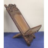 Modern African Nigerian carved hardwood folding chair in two parts, the arched top with mask head