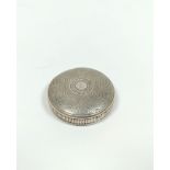 Silver circular snuff box of watch case style, engine turned all over with gold joint and gilt