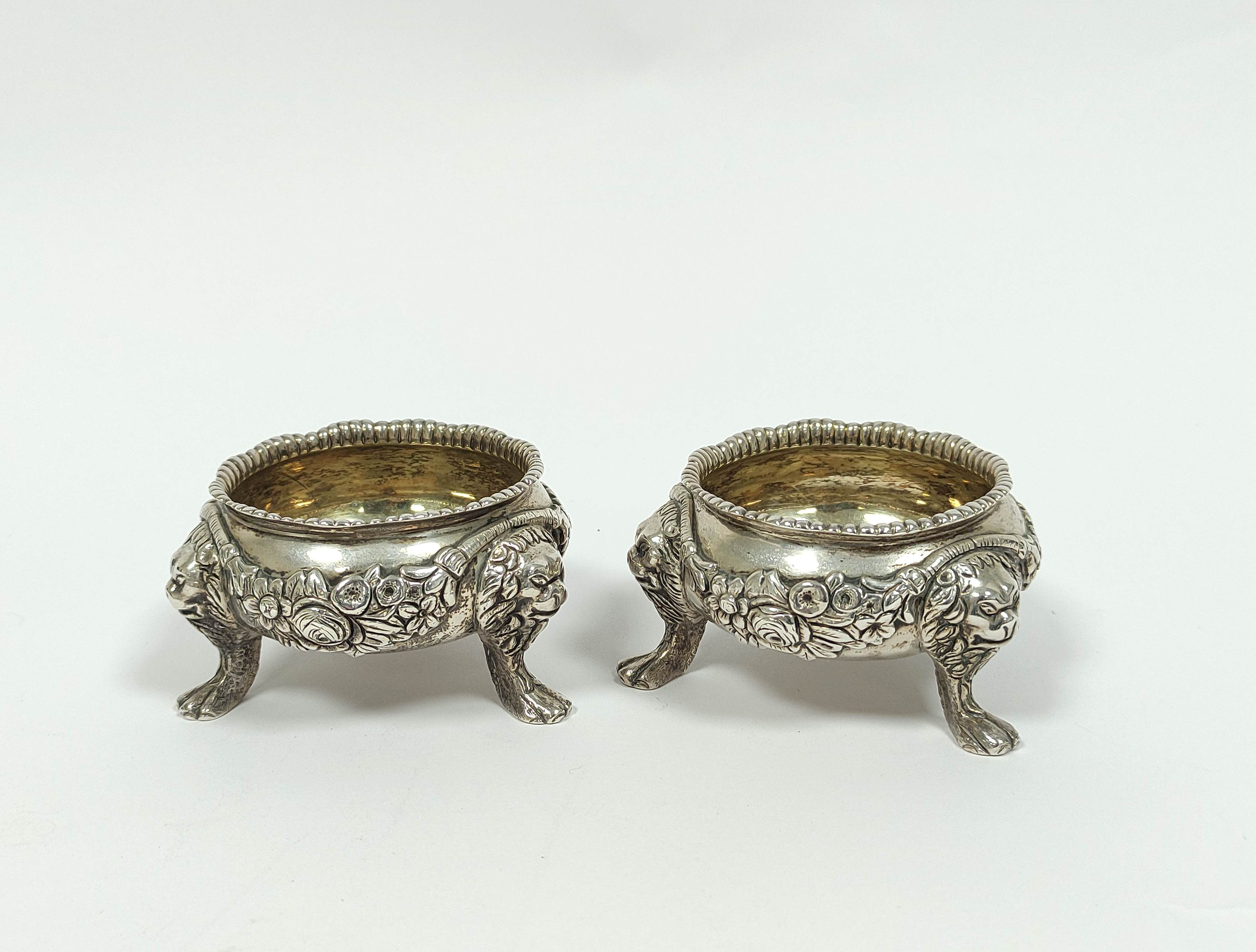 Pair of cast silver salts and good gauge with embossed swags, upon lion mask and furry paw feet,