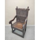 17th century wainscot chair, the foliate carved panel back with acorn finials, above solid seat,