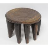 African tribal Nigerian Nupe hand carved wooden stool of circular form with ten tapered legs and