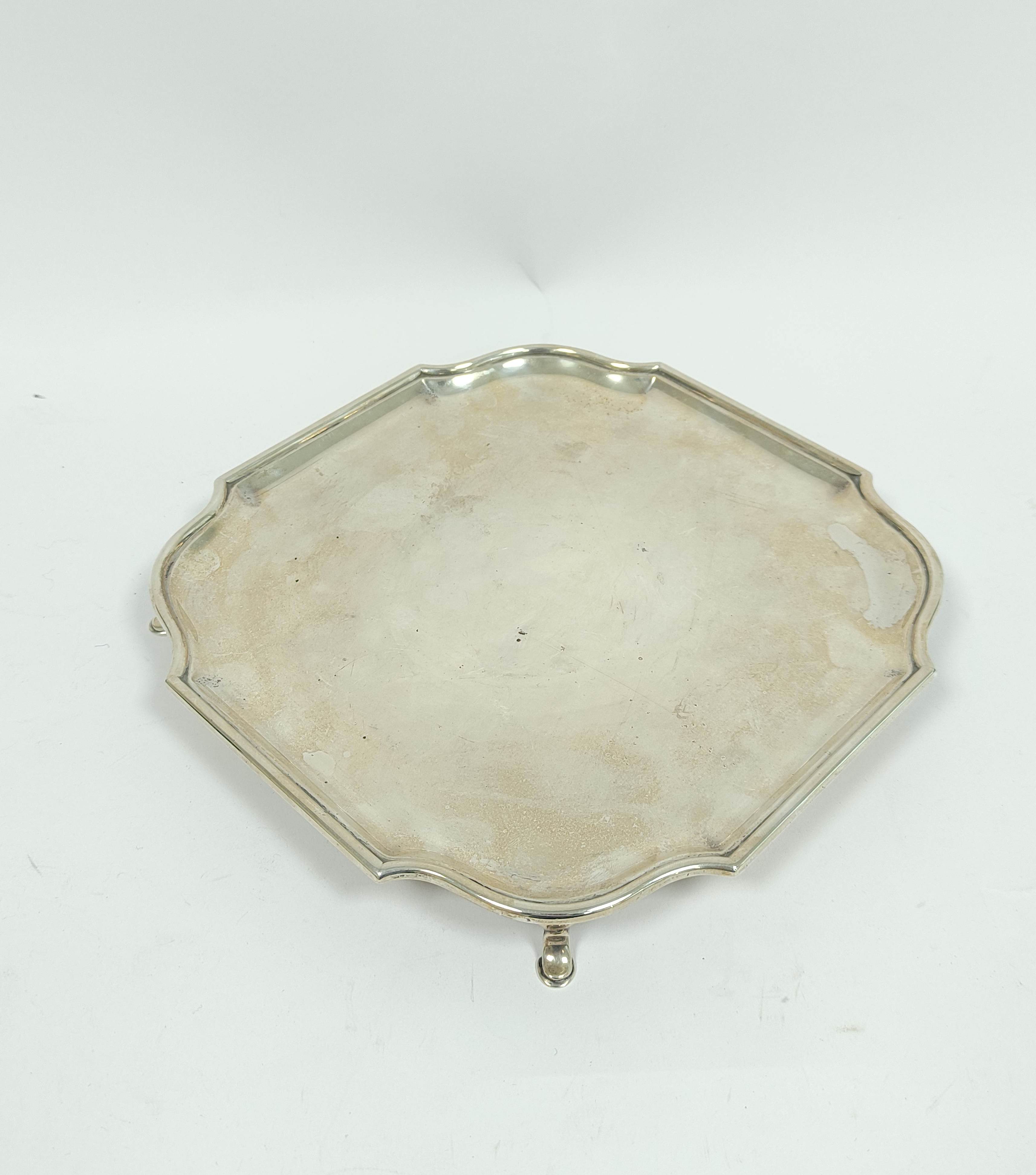 Silver tray of shaped square form with bath border on pad feet, Sheffield 1931, 22cm, 465g / 14½oz.