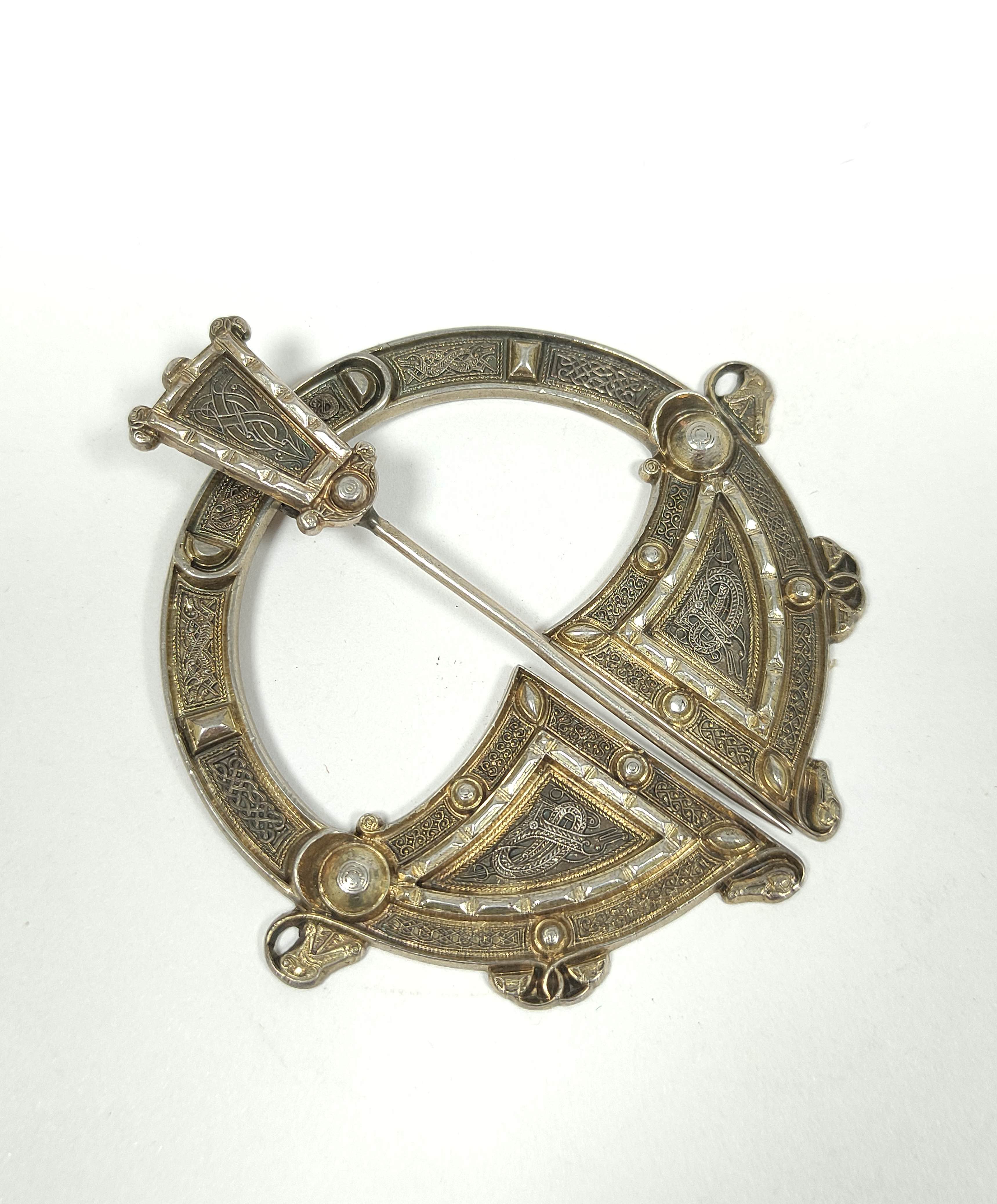 Silver gilt penannular pin, unmarked with embossed Celtic motifs and plain back, 70mm.