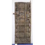 African carved wooden door, probably Dogon, Mali, profusely decorated with figures and animals,
