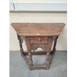 17th century style oak credence table, the shaped top above carved decoration, raised on turned