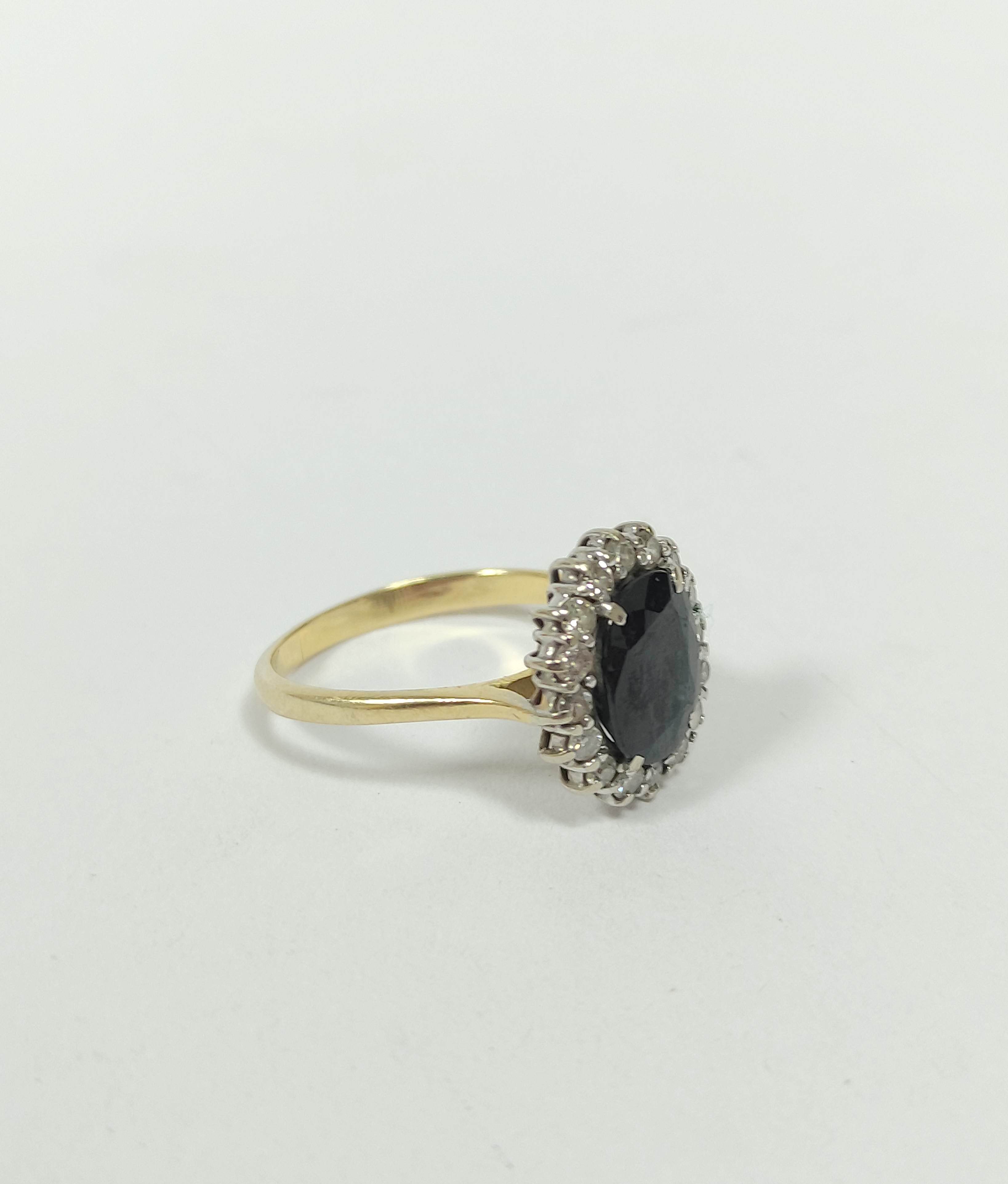 Diamond and sapphire oval cluster ring with small brilliants in gold, '18ct', size 'P'.