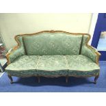 French Louis XV style three-seater settee with padded arms, floral carved frame with cabriole