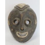 African tribal mask of ovoid form with cylindrical eyes, mouth with jagged teeth and stylised