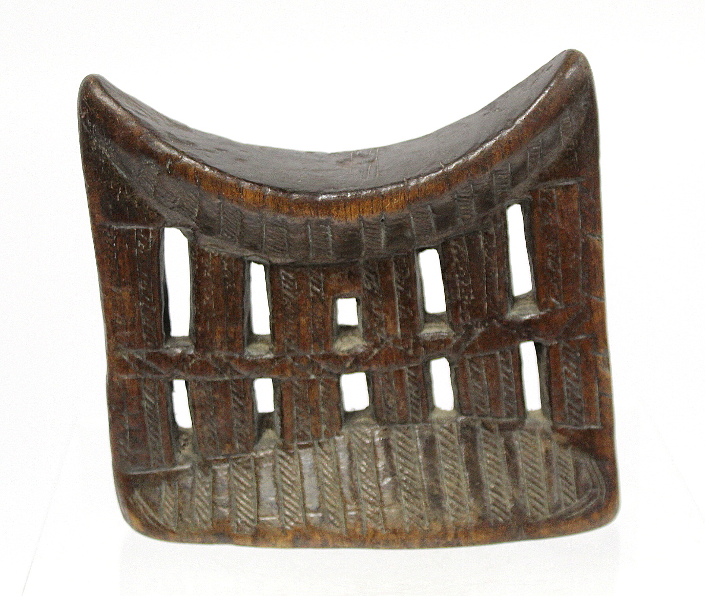 African tribal Ethiopian Kambatta pierced and carved wooden headrest, 19cm wide, 18cm high.