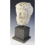 A carved stone head, the male head distinctively carved with curled hair and beard, 29cm high,