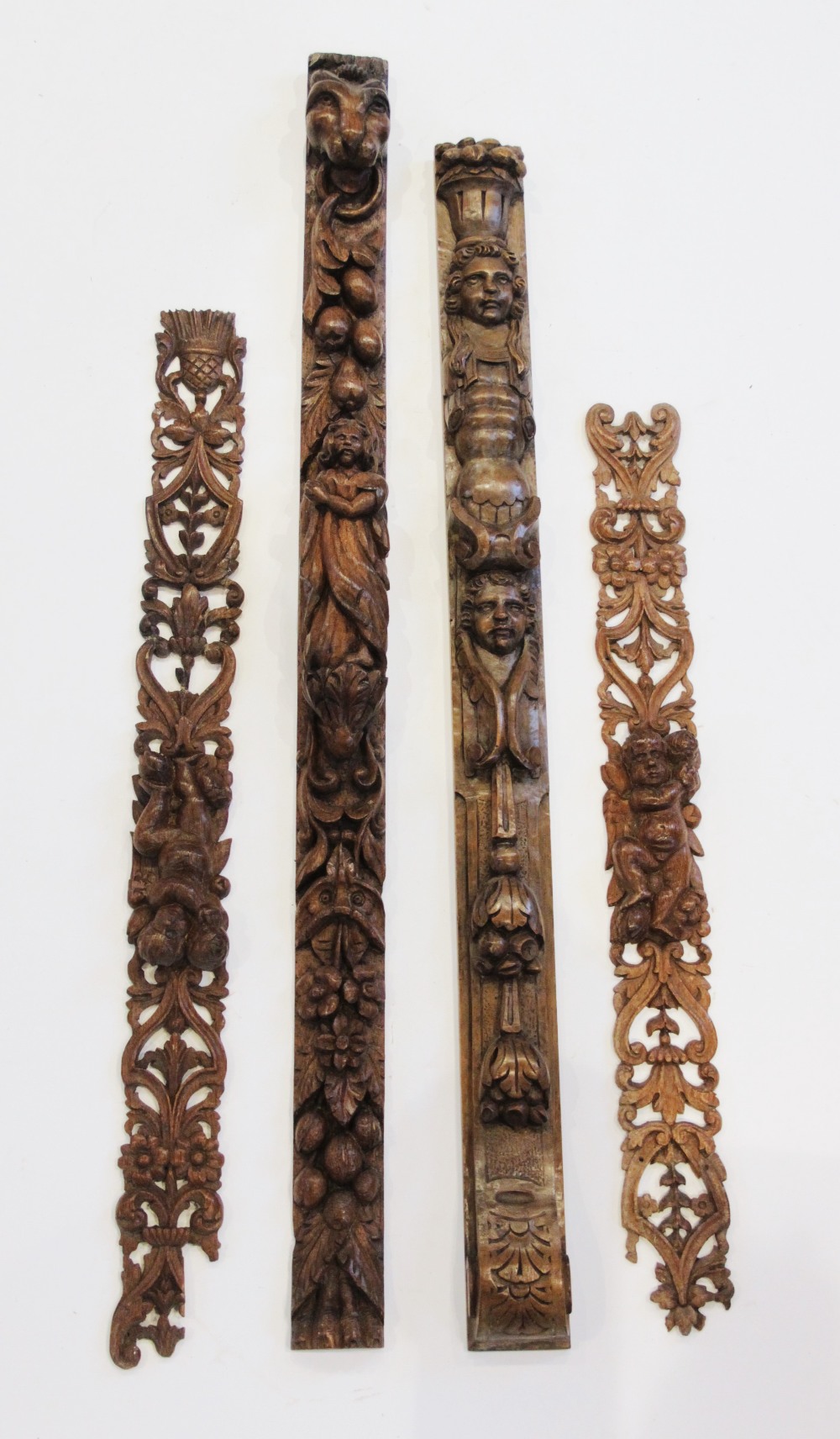 An oak carved figural pilaster, Flemish, topped by lions mask above hanging fruit, foliage and
