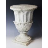 A marble plinth, the urn base with relief carved acanthus leaves to body upon a stepped spreading