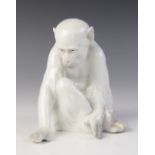 A porcelain figure of a monkey observing its hand, probably by Heubach Gebrüder, white glazed