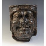 A late 15th/early 16th century carved oak corbel, depicting a male grimacing, 21cm H (excluding