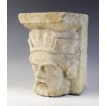 A carved stone corbel, in the medieval style, depicting the head of a bearded gentleman wearing a