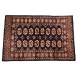 * A small hand woven bokhara wool carpet, of typical design, with sixteen medallions against a
