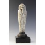 An Egyptian style limestone mummiform figure with lappet wig and false beard, traces of polychrome
