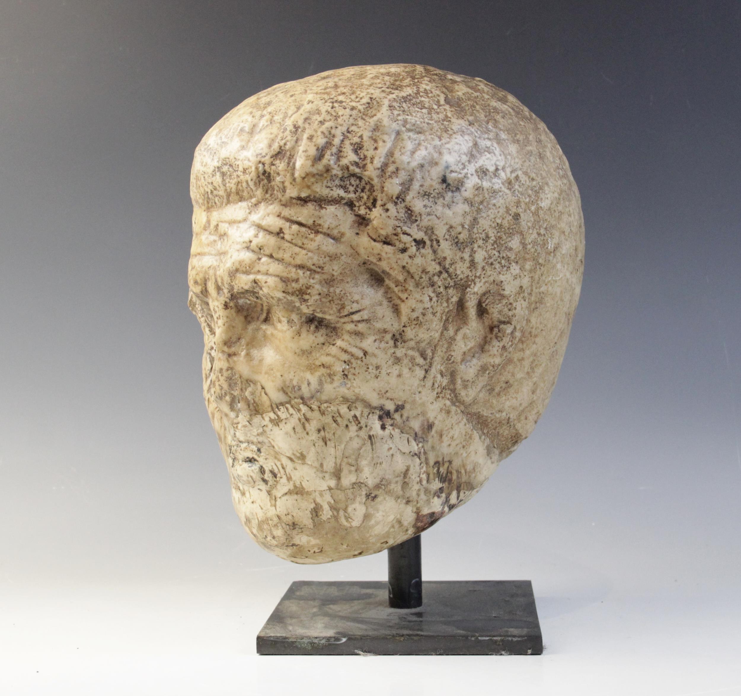 A worn marble male head carved with deeply furrowed brow, with restorations, 26cm high Provenance: - Image 2 of 8