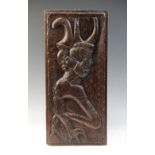 A 16th century carved oak panel, carved with a grotesque beast against a naïve scalloped and foliate