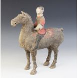 A Chinese pottery model of a figure riding a horse, possibly Han dynasty, the horse standing on four
