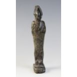 An Egyptian basalt mummiform figure of Osiris, with carved details of the crook and flail, wearing