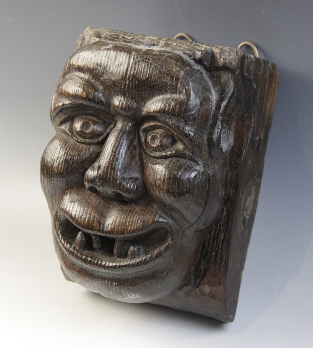 A late 15th century grotesque figural corbel, designed as a male smiling and bearing his teeth, 23.