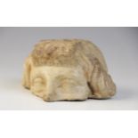 A fragmentary upper half of a head, with carved eyes and wavy hair framing the face, 5cm x 10cm