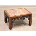 A Chinese hardwood and rouge marble urn stand, of rectangular form with interlinked openwork frieze,