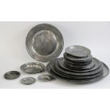A large selection of 17th century and later pewter chargers, including a large example with touch