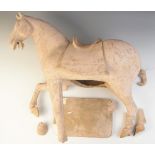 A large Chinese pottery model of a horse, possibly Tang dynasty, modelled on four legs, with one