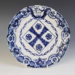 A delft plate dated 1725, blue painted with a central lozenge with four stylised flower heads,