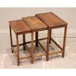 * A nest of three Chinese carved teak tables, early 20th century, each carved with a border frieze