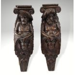 A pair of 17th century oak figural terms, Flemish, each carved with a male bust wearing a hat