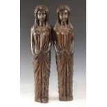 A pair of carved oak figures, each modelled as a robed female with flowing hair, in the 16th century