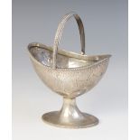 A silver coloured swing-handled sugar basket