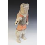 A Chinese pottery warrior, possibly Han dynasty, modelled standing wearing armour and painted in