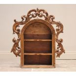 An 18th century and later constructed pine niche, of enclosed arched form with a carved scrolling