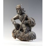 A carved oak hanging figure, circa 1600, carved as a kneeling man holding a staff, upon acanthus